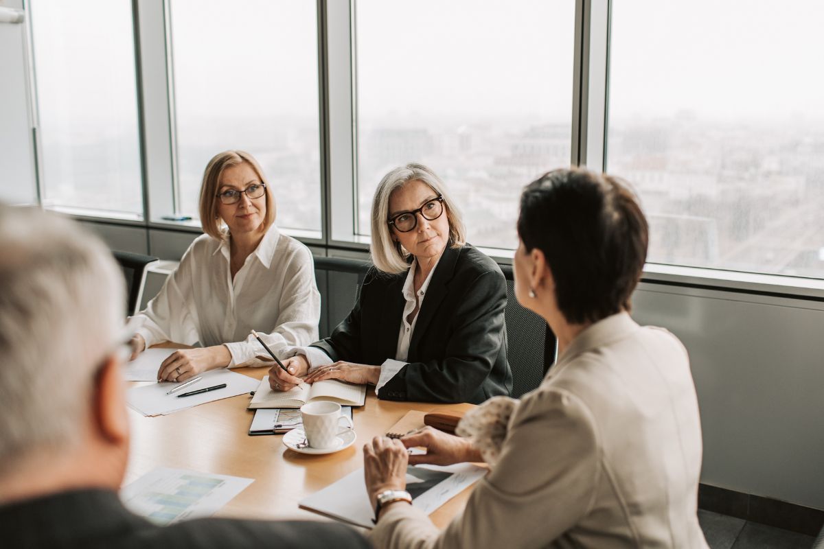 women sat around meeting table