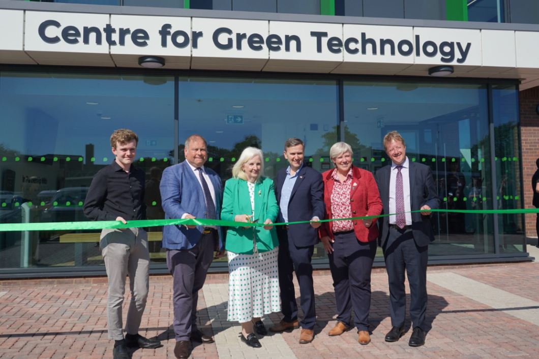 People standing outside of peterborough college about to cut the ribbon to open the new centre