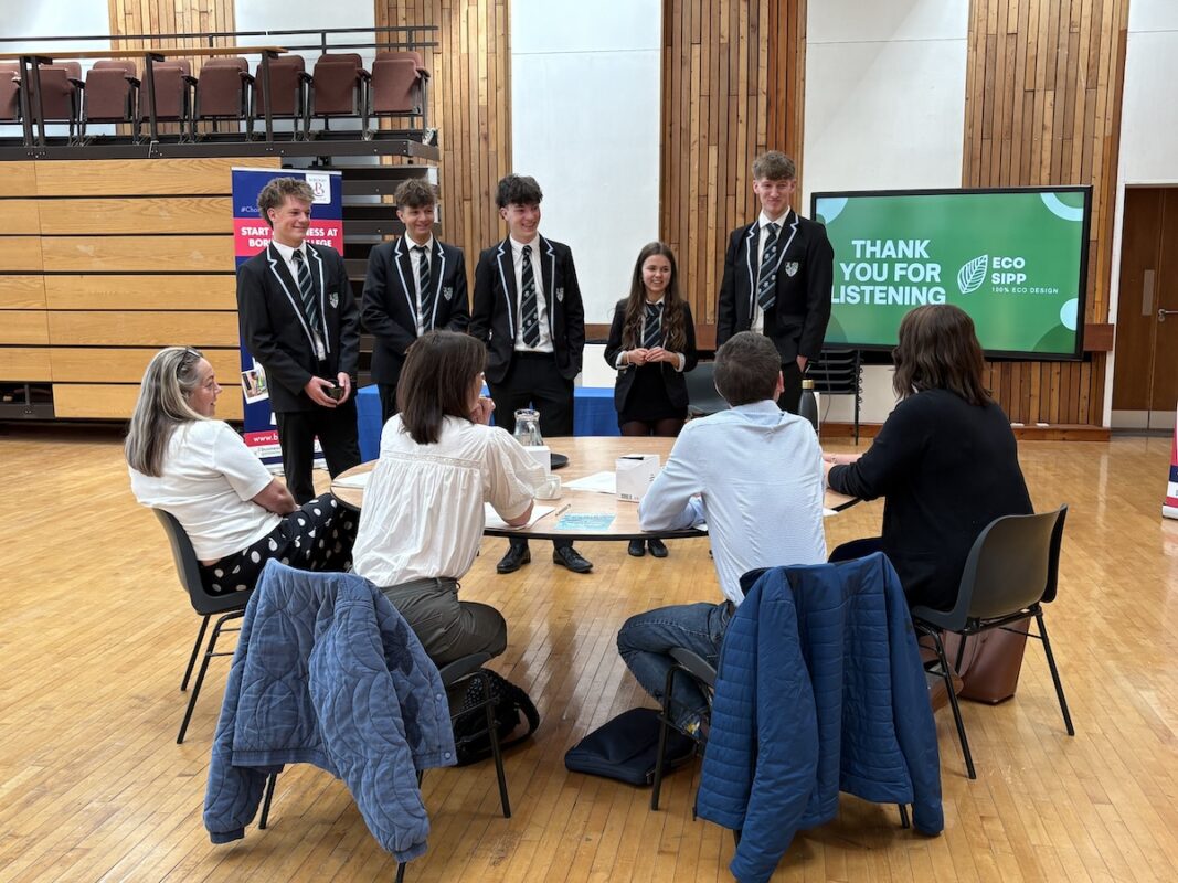Group of students standing having a discussion with a judging panel