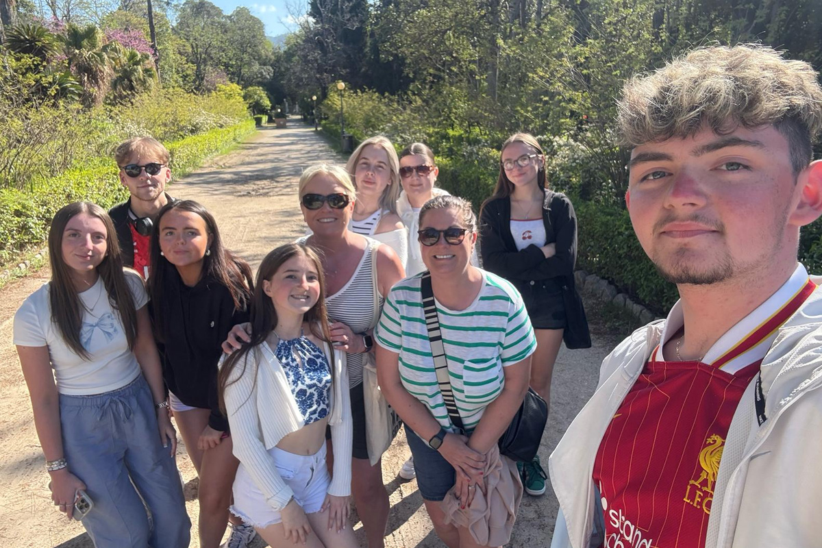 A selfie style picture of students on the trip in a sunny park.